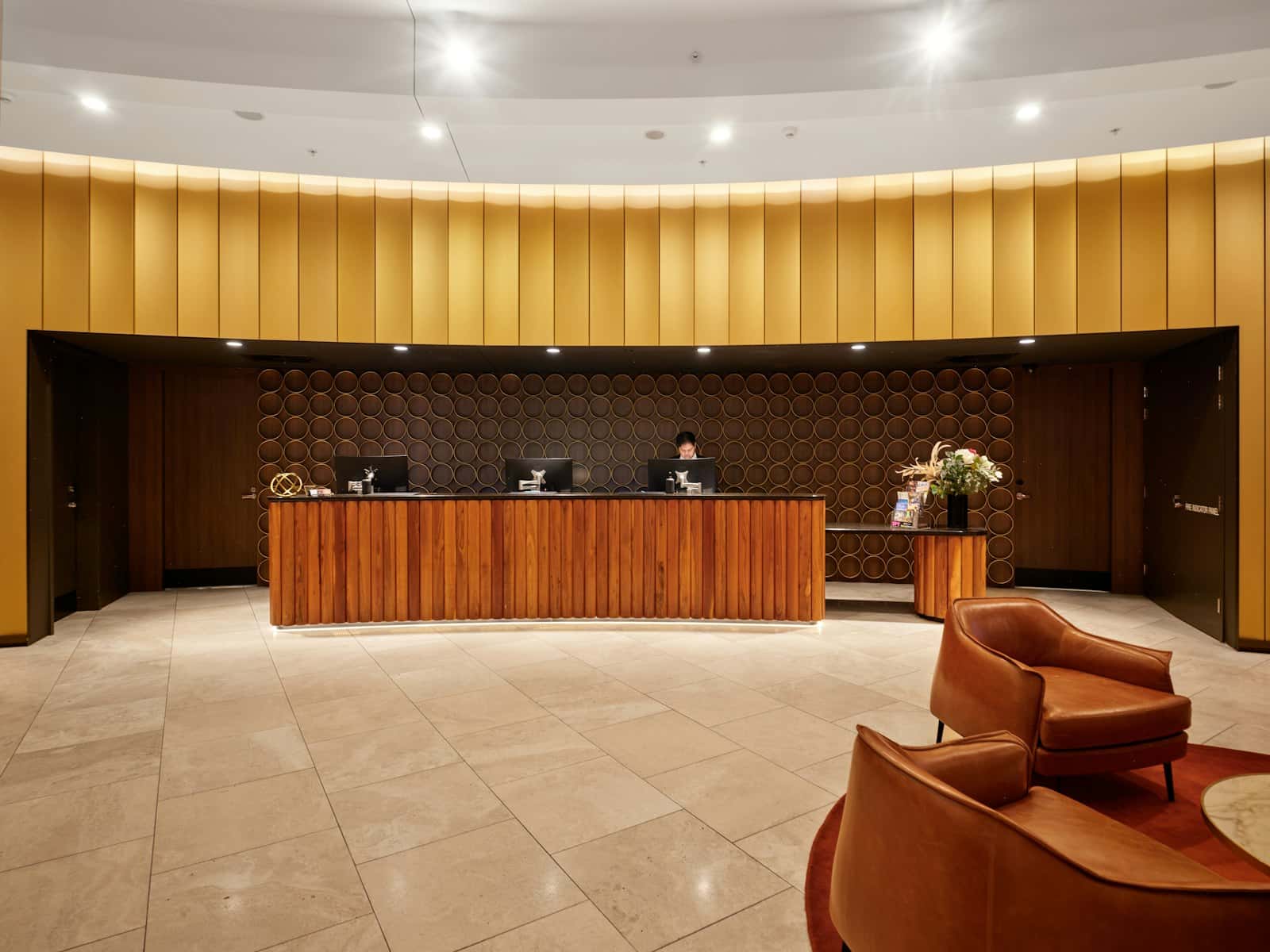 A hotel reception desk with wooden furniture and seating