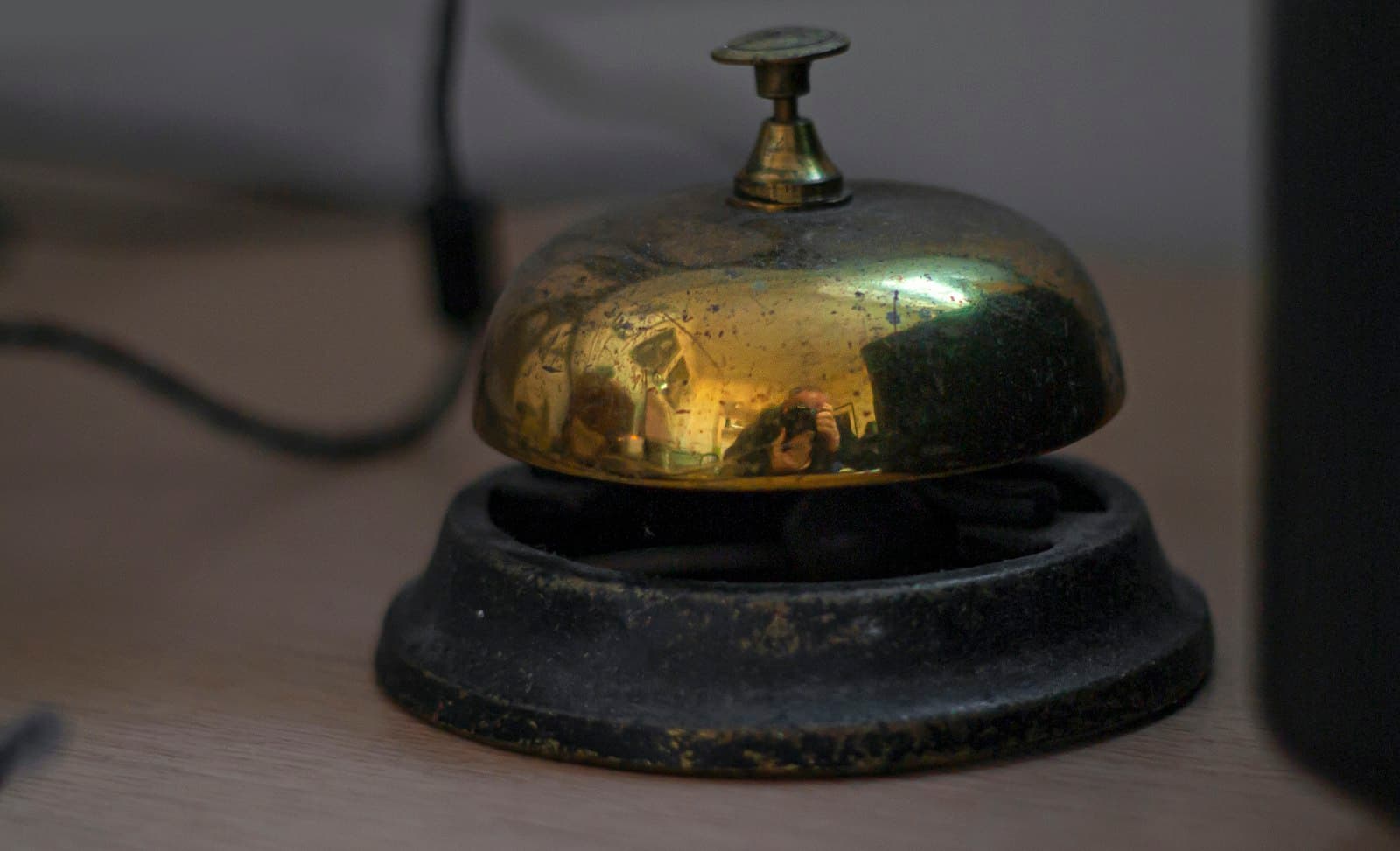 A brass service bell on a hotel reception desk